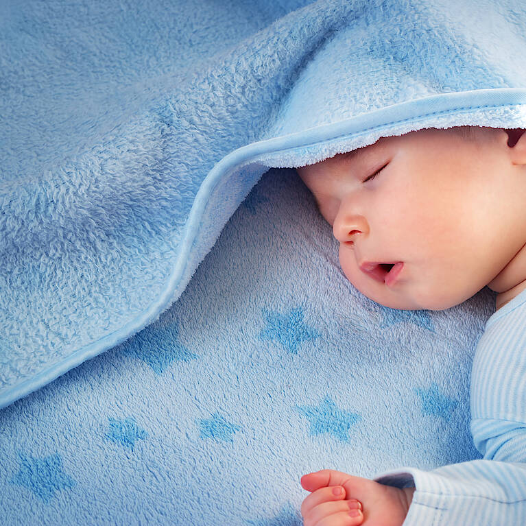 Baby in blauer Decke